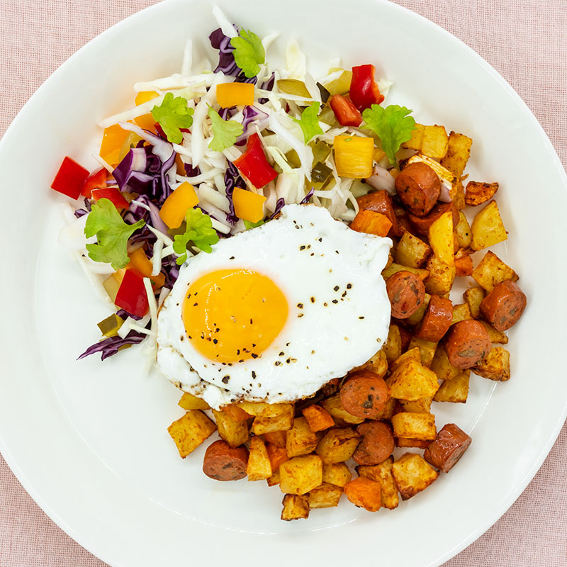 vegaaninen airfryer pyttipannu, paistettu kananmuna ja kaali-maustekurkkusalaattia